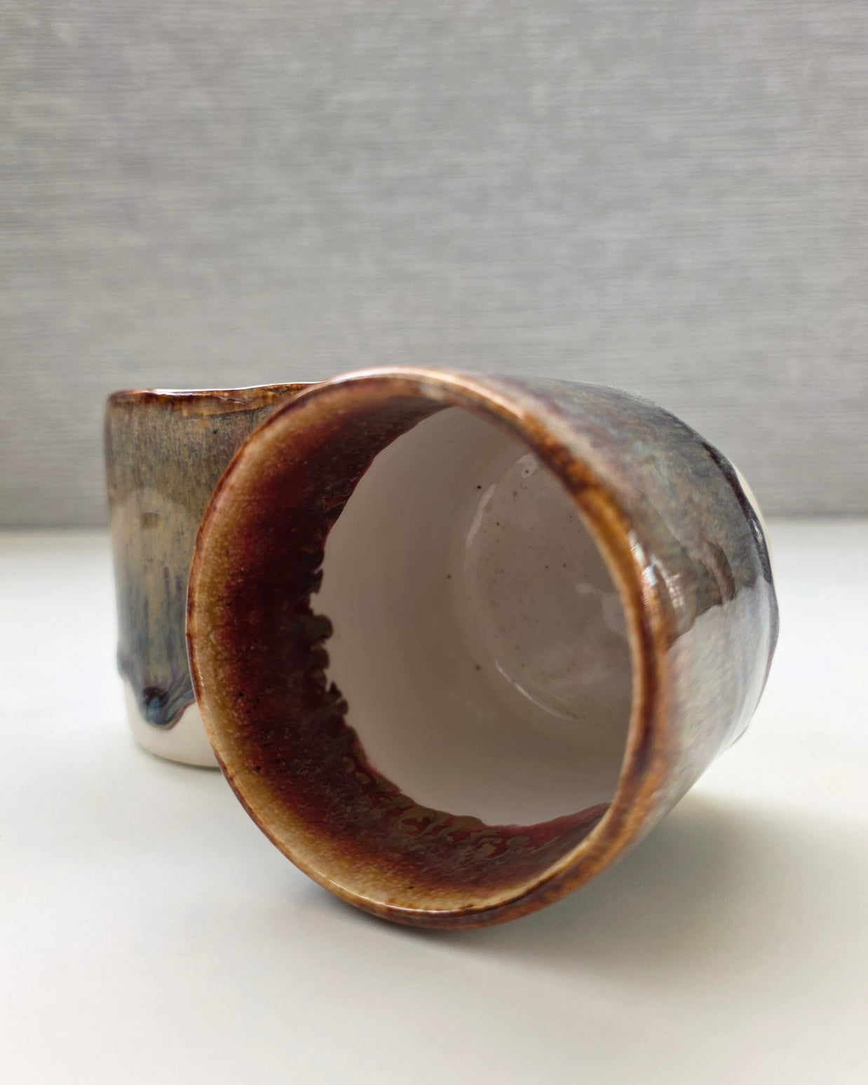 interior of handmade ceramic cup with speckled base and amber-brown rim