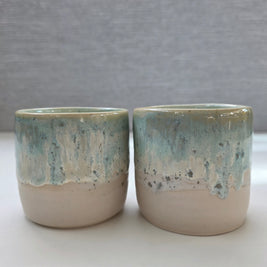 set of two handmade ceramic cups with seafoam green and blue glaze over a warm white-beige base