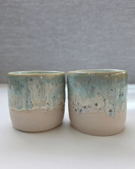 set of two handmade ceramic cups with seafoam green and blue glaze over a warm white-beige base