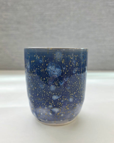 handmade ceramic cup with periwinkle glaze and small yellow speckled details