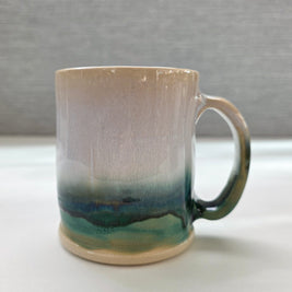 handmade ceramic mug with a handle, finished in a soft gradient glaze transitioning from warm white to a deep green base