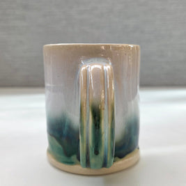 handmade ceramic mug with a handle, finished in a soft gradient glaze transitioning from warm white to a deep green base