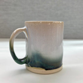 handmade ceramic mug with a handle, finished in a soft gradient glaze transitioning from warm white to a deep green base