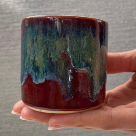 handmade ceramic lungo cup with deep maroon glaze and teal wash detail