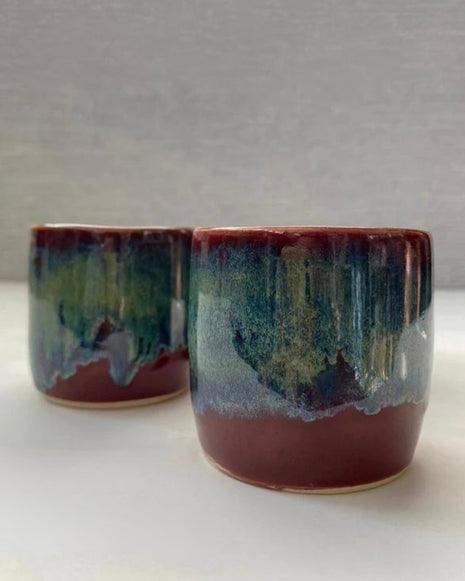 set of two handmade ceramic lungo cups with deep maroon glaze and teal wash detail