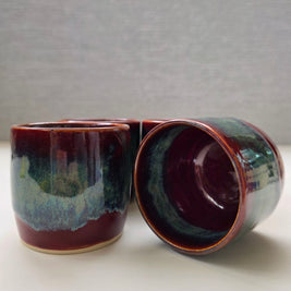 set of two handmade ceramic lungo cups with deep maroon glaze and teal wash detail