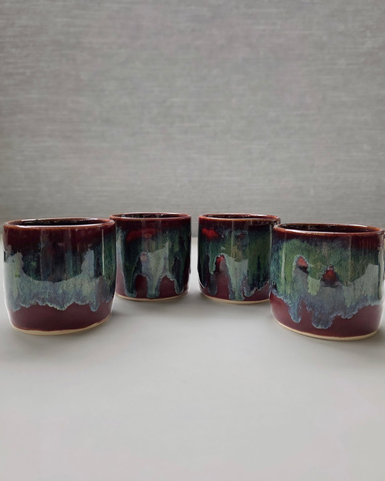 handmade ceramic lungo cups with deep maroon glaze and teal wash detail