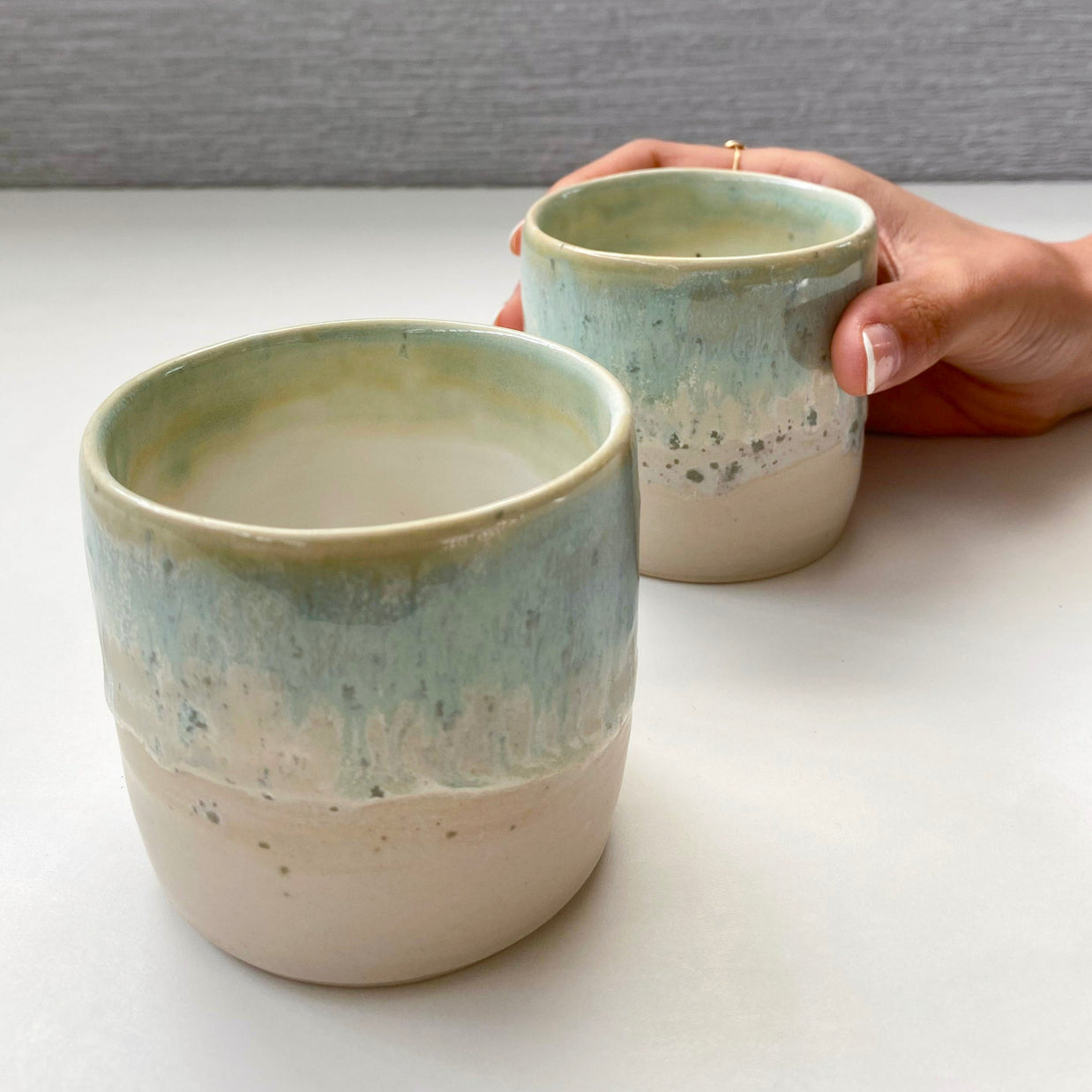 set of two handmade ceramic cups with seafoam green and blue glaze over a warm white-beige base (medium size)